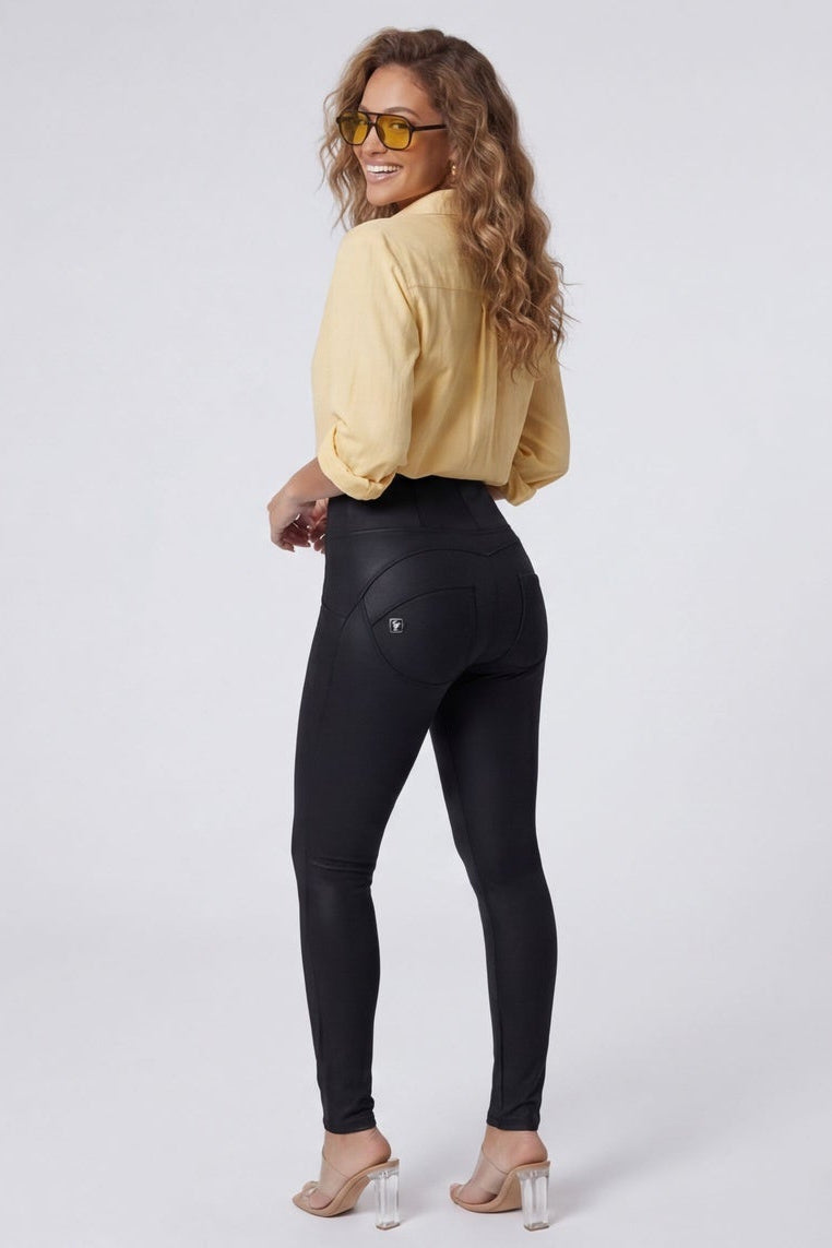 Woman wearing a yellow shirt and black leggings on a white background