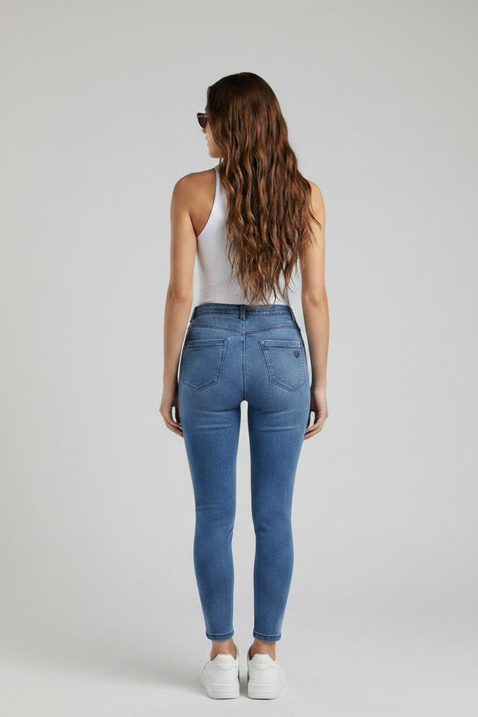Woman modeling blue jeans from front, back, and side views on a gray background.