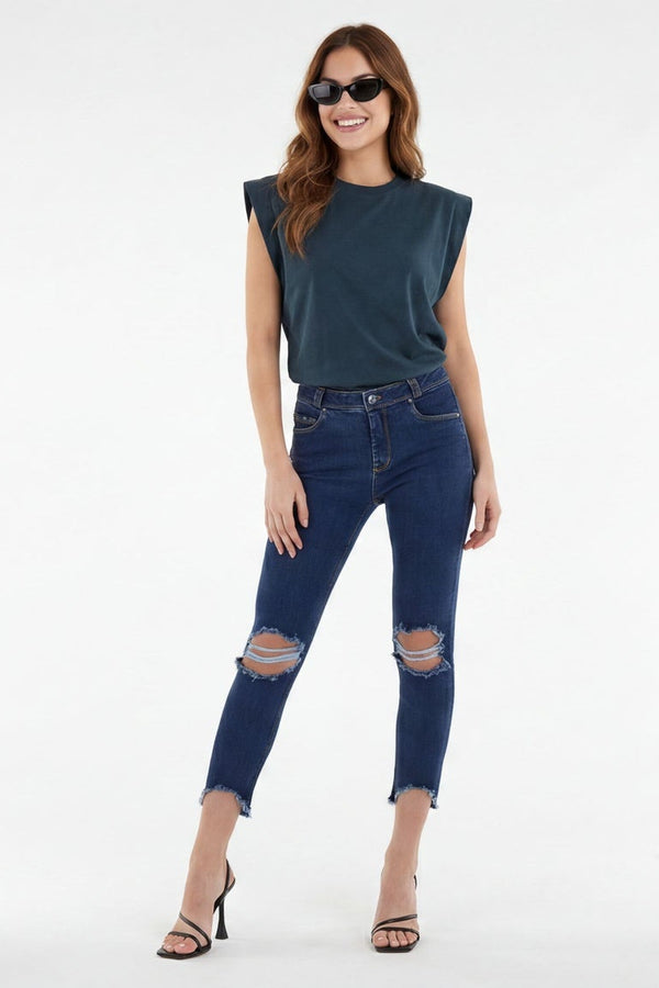 Woman wearing blue jeans and a sleeveless top on a white background