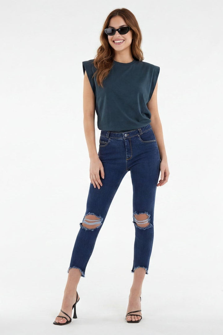 Woman wearing blue jeans and a sleeveless top on a white background