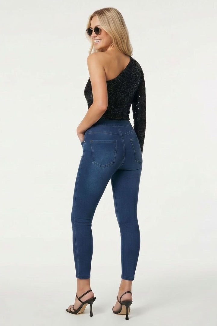 Two women wearing blue jeans and black tops on a white background