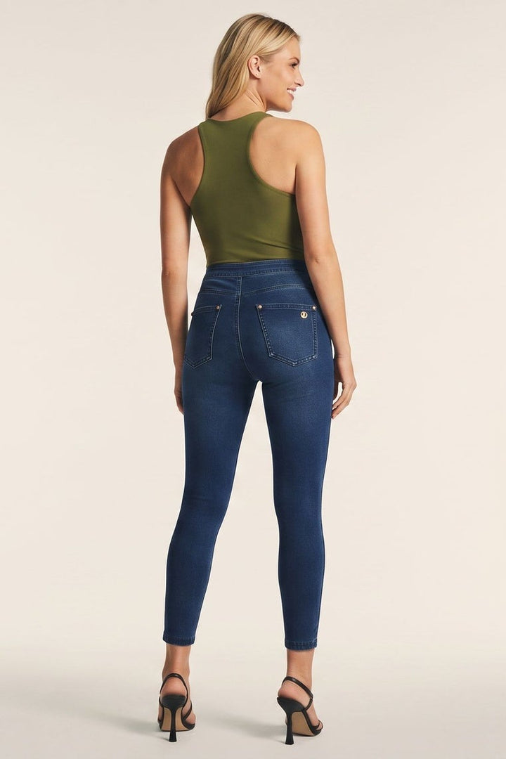 Woman wearing blue jeans and a green top, shown from front and back on a beige background