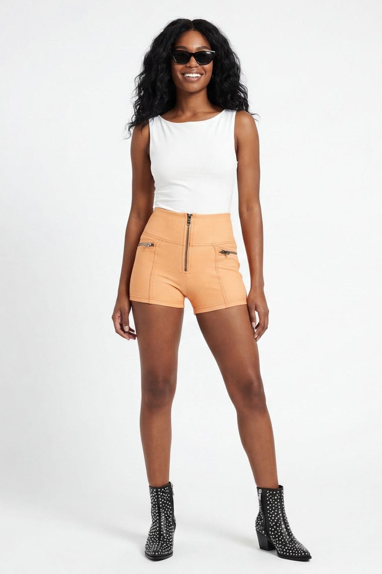 Woman wearing a white top and beige shorts on a white background