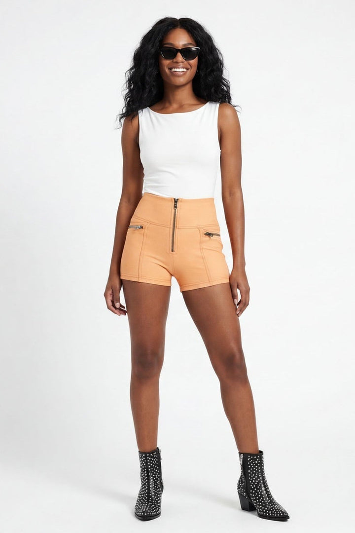 Woman wearing a white top and beige shorts on a white background