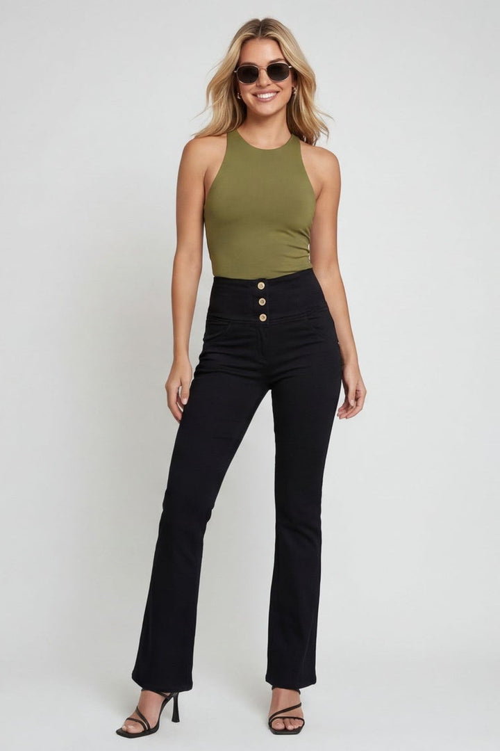 Woman wearing a green top and black pants on a white background