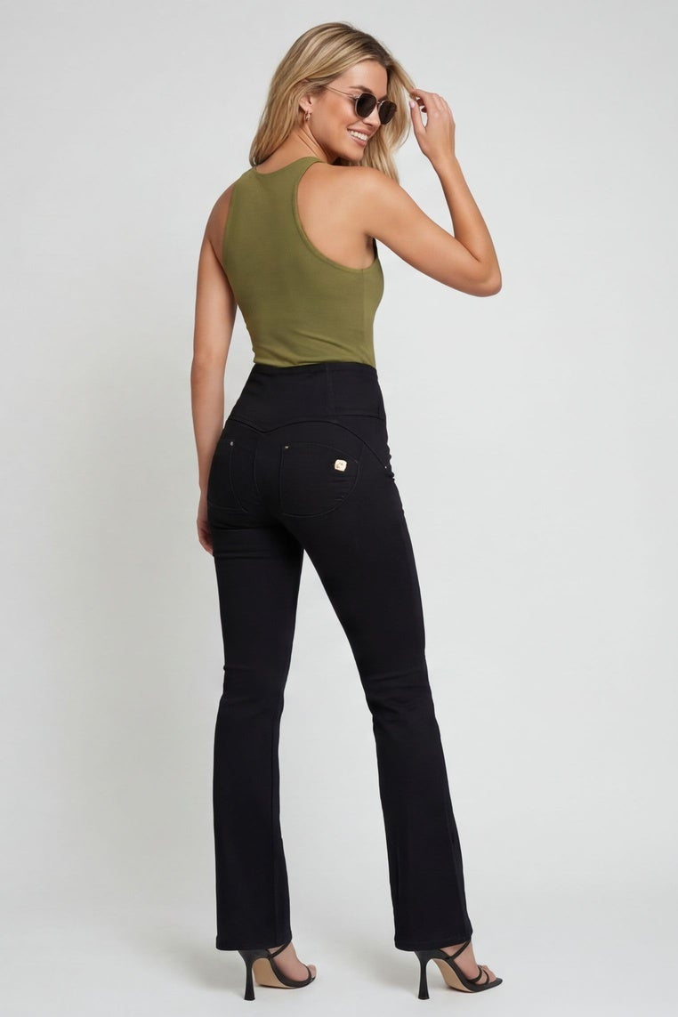 Woman wearing a green top and black pants on a white background