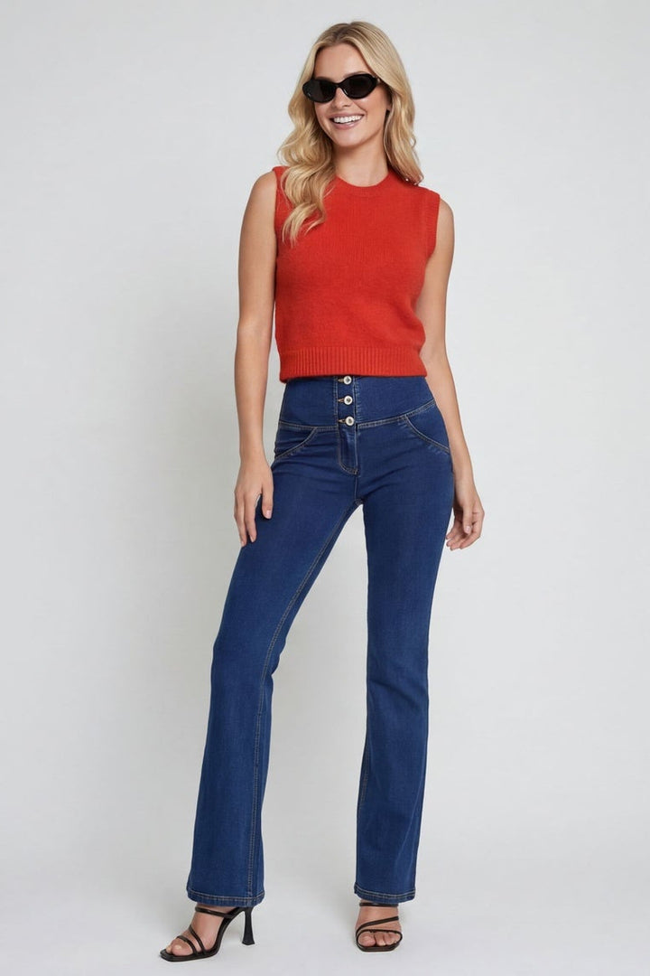 Woman wearing a red top and blue jeans on a white background