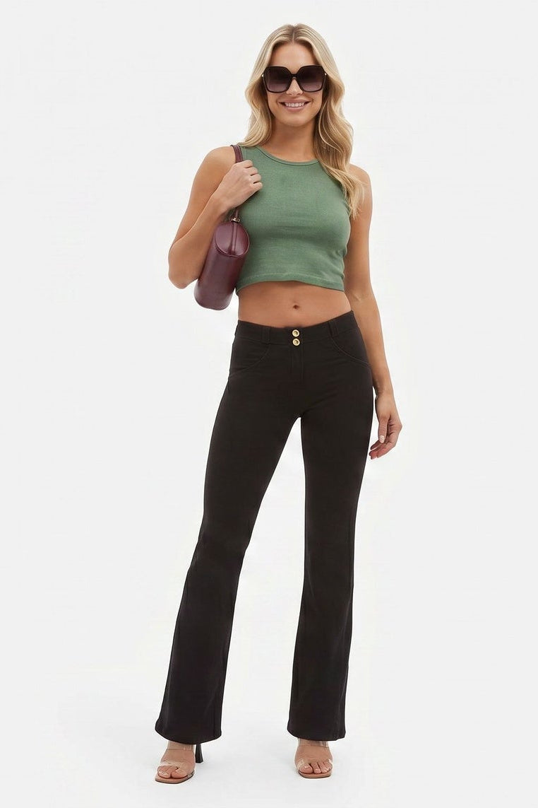 Woman wearing a green top and black pants on a white background