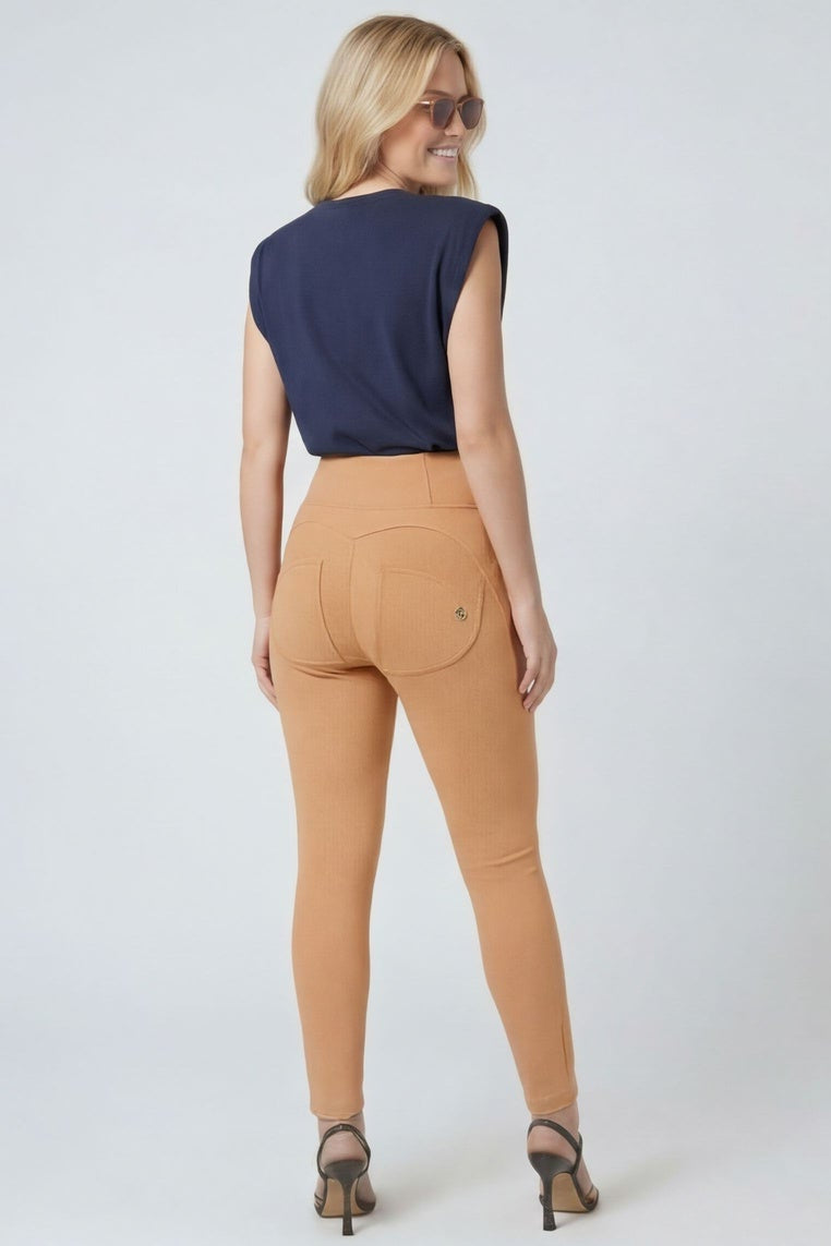 Woman wearing a navy top and tan pants, shown from front and back on a white background.