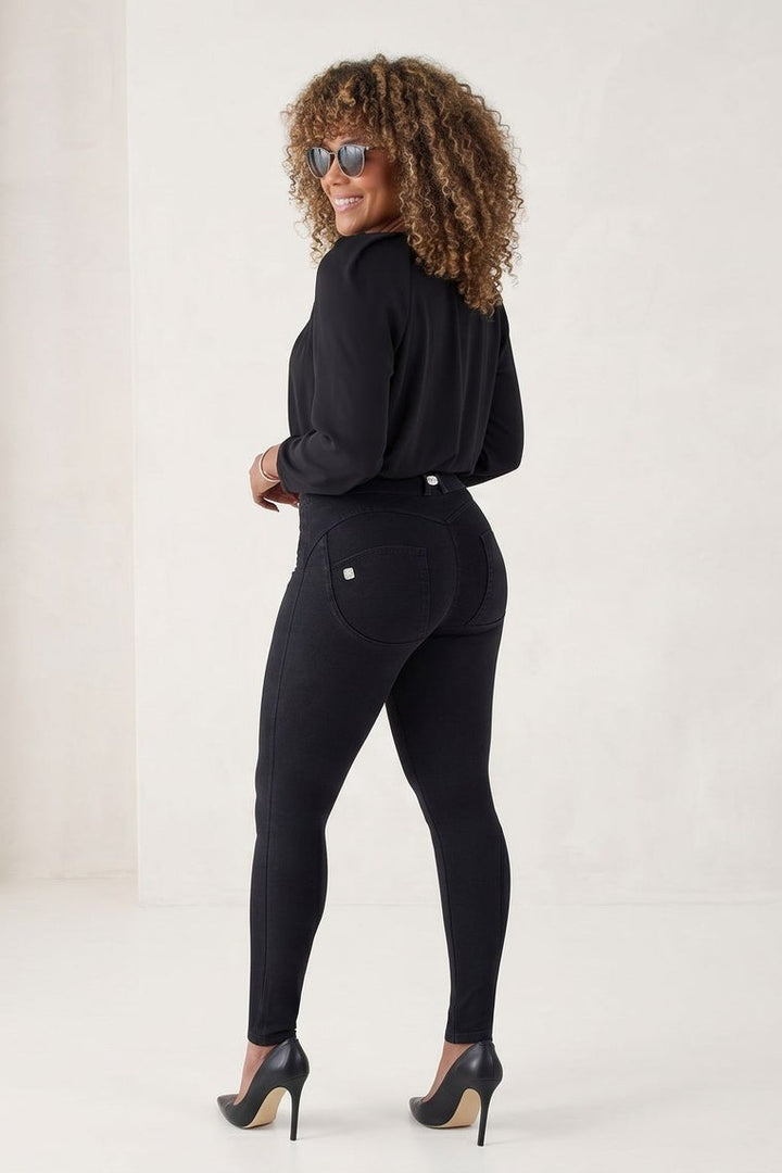 Woman wearing a black outfit with sunglasses on a white background