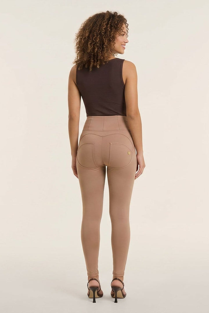 Woman wearing a brown sleeveless top and beige pants, facing front and back, on a white background.