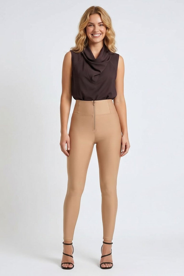 Woman wearing a brown sleeveless top and beige pants on a white background