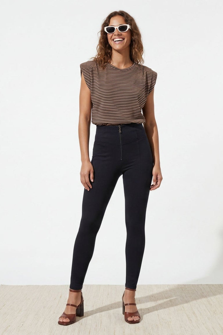 Woman wearing a brown sleeveless top and black pants, shown from front and back on a white background.