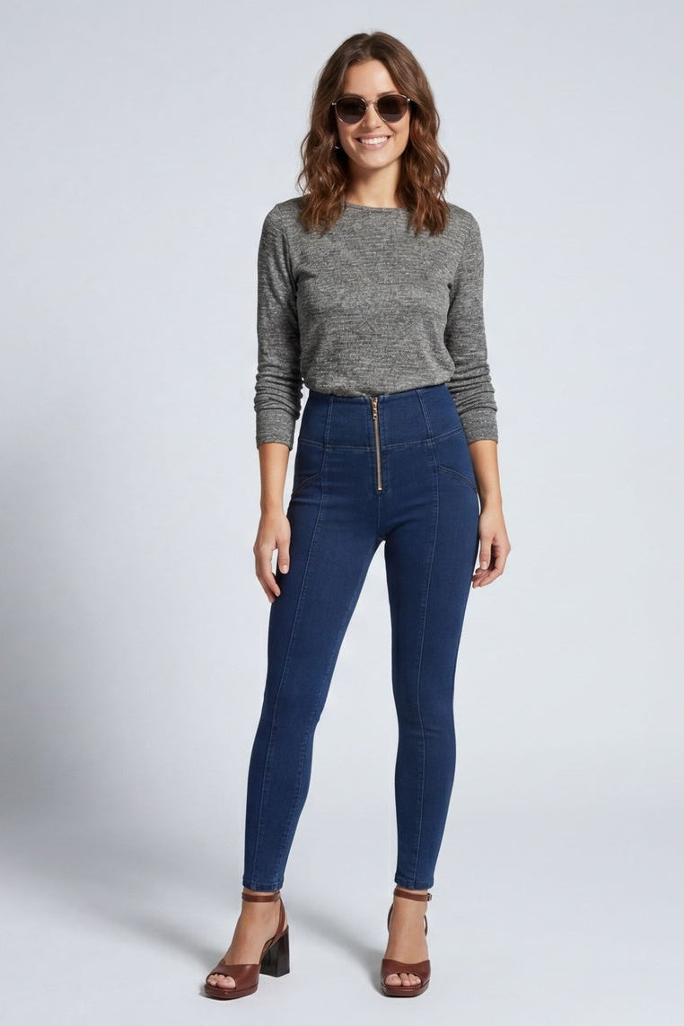 Woman modeling blue jeans from front and back on a white background