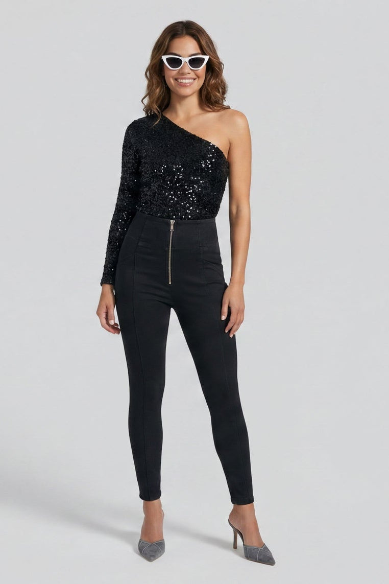 Woman wearing a black one-shoulder jumpsuit with sequins on a white background