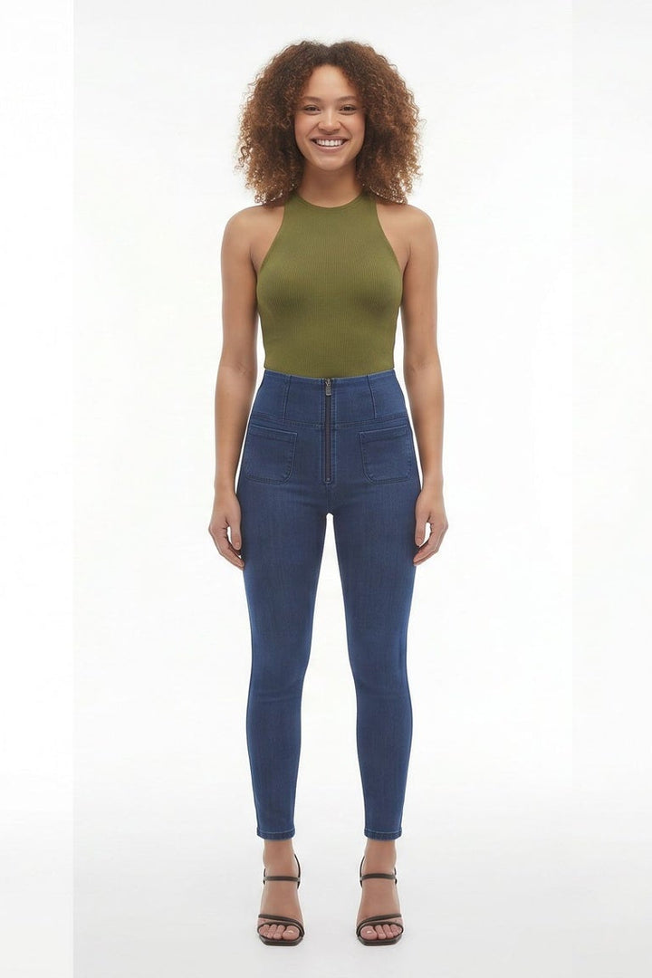Woman wearing a green top and blue jeans on a white background