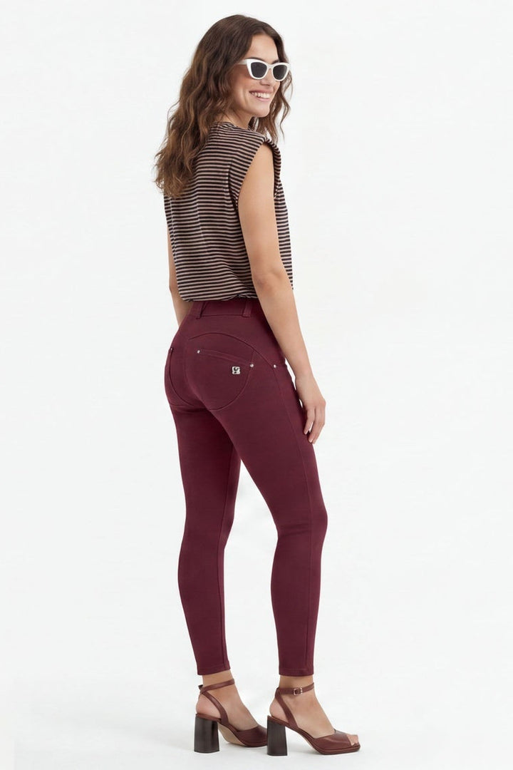 Woman wearing maroon pants and a brown top, shown from front, side, and back views on a white background.