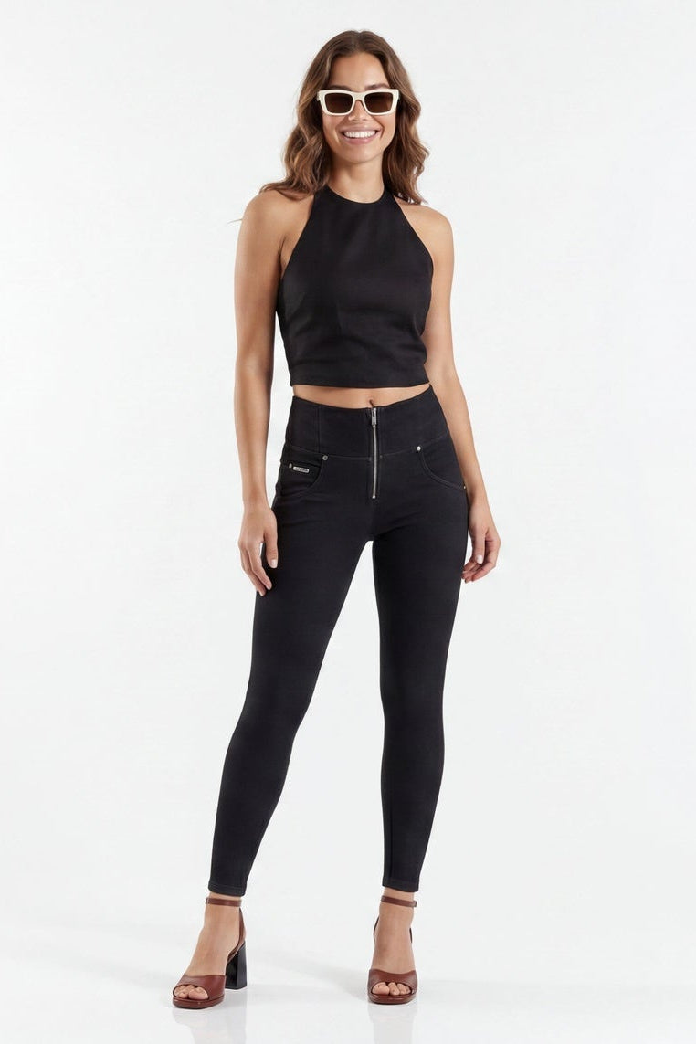 Woman modeling black high-waisted jeans from front and back on a white background