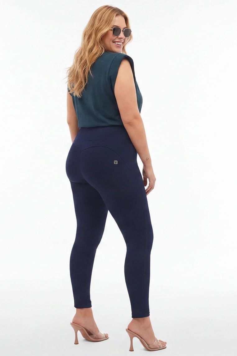 Woman wearing a teal top and navy leggings from front and back views on a white background