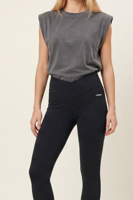 Woman wearing black leggings and a gray top, shown from front and side views on a light background.