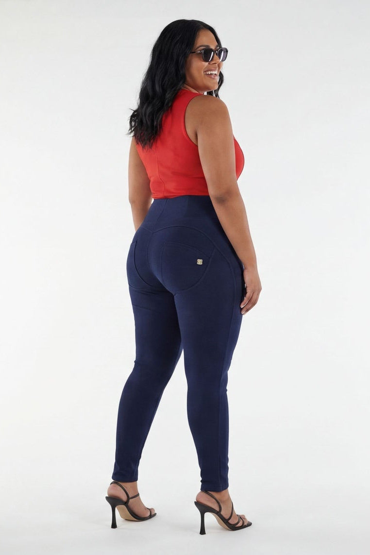 Woman wearing a red top and navy blue pants on a white background